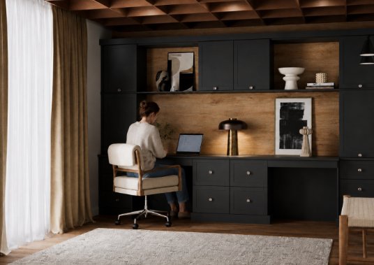 A combined wardrobe and working space with a women sat working on her laptop