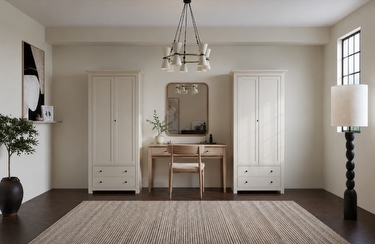 Two free standing white wardrobes with a table and mirror in between