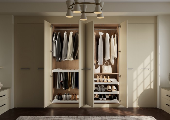 A fitted cream wardobe with the middle two doors open